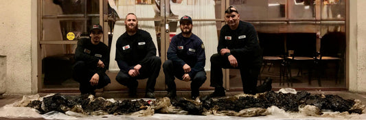 Greasers kneeling behind grease removed from kitchen exhaust